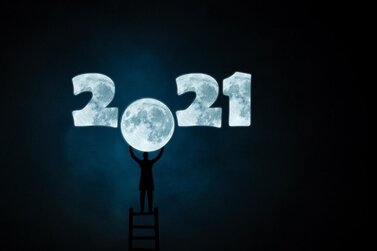 2021 sign with person holding up a moon
