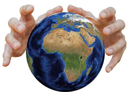 Image of Planet Earth being held and shaped by two white-skinned hands