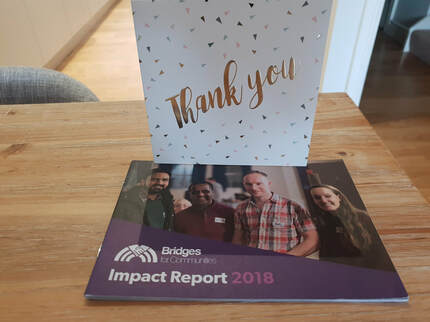 Photo of the thank you card and impact report received from Bridges for Communities