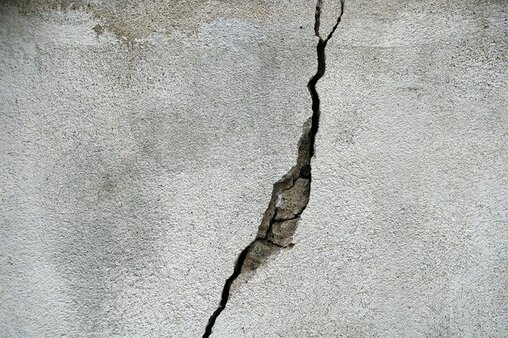 Crack in grey concrete wall