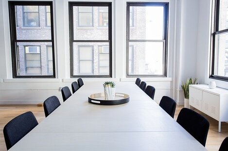 Empty boardroom with central table and ten empty chairs