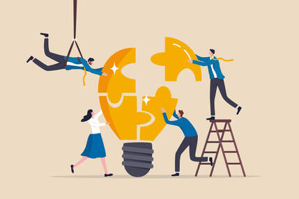 Four people are working together to piece together a lightbulb made from jigsaw pieces. Two are standing on the ground, one is stood on a ladder and one is attached to the ceiling with a winch.